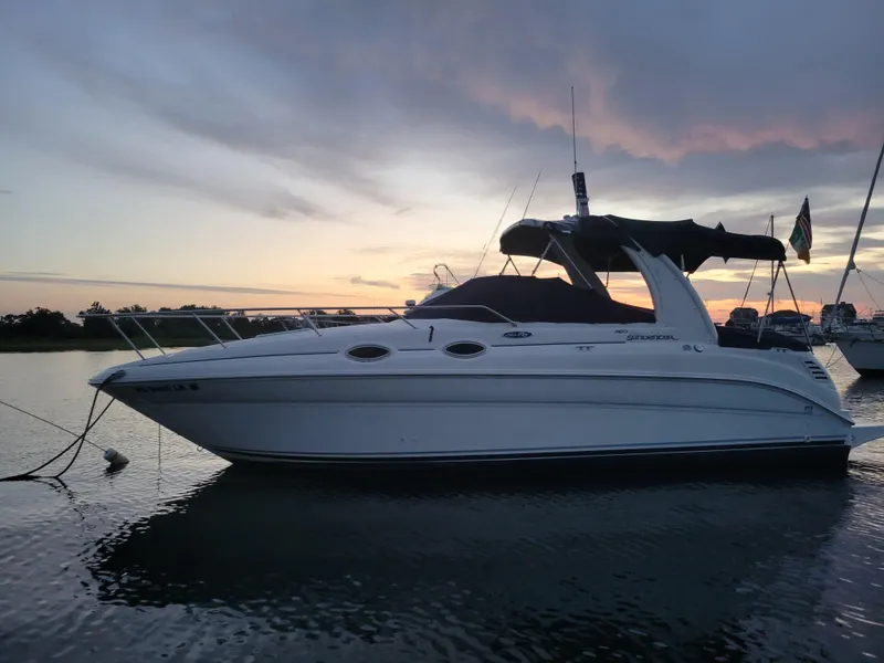 Slide: The Image of 2004 Sea Ray Sundancer 260 boat at sunset, anchored on calm water. - 2