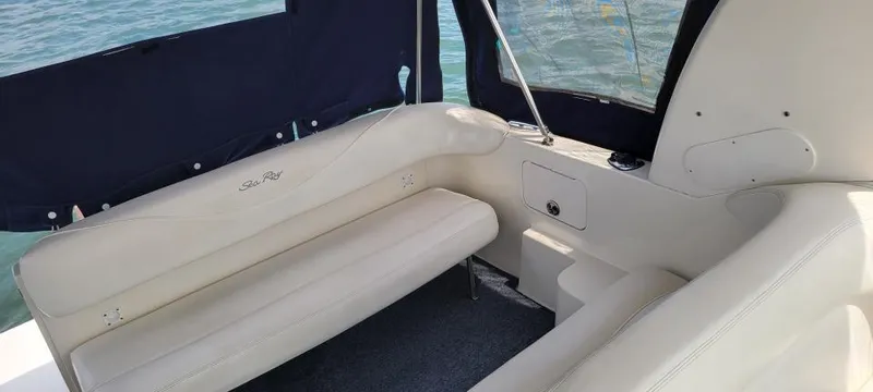 Slide: The Image of 2004 Sea Ray Sundancer 260 interior with white seating and navy canopy. - 21