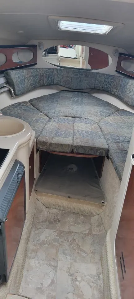 Slide: The Image of 2004 Sea Ray Sundancer 260 cabin interior with cushioned seating and overhead skylight. - 25