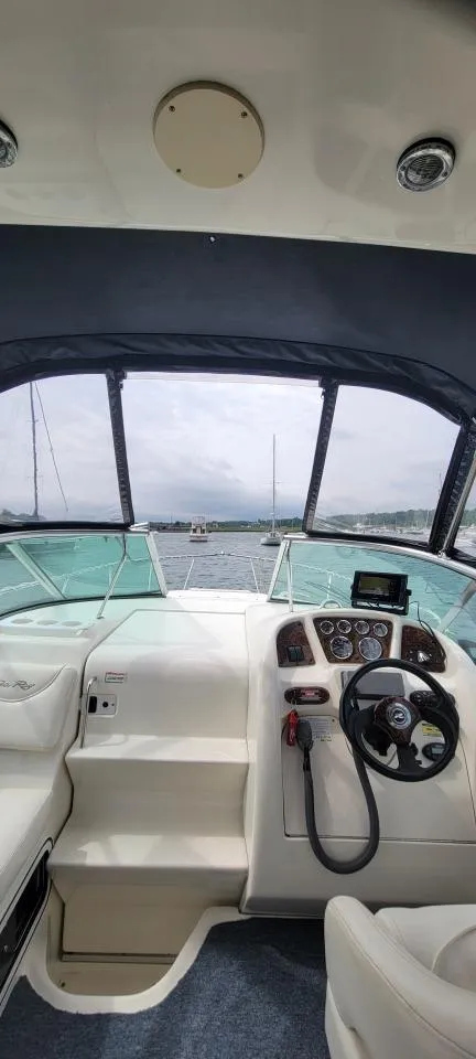 Slide: The Image of Interior view of 2004 Sea Ray Sundancer 260 boat cockpit with steering wheel and controls. - 26