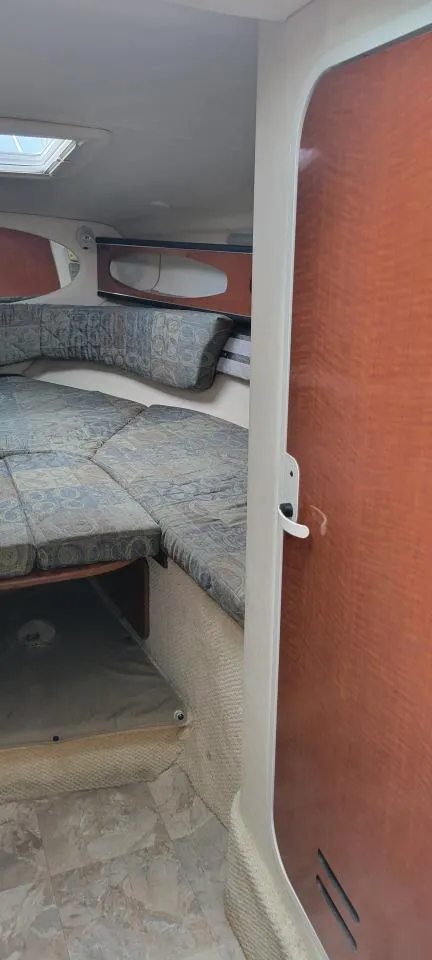 Slide: The Image of 2004 Sea Ray Sundancer 260 cabin interior with cozy seating and wooden accents. - 28