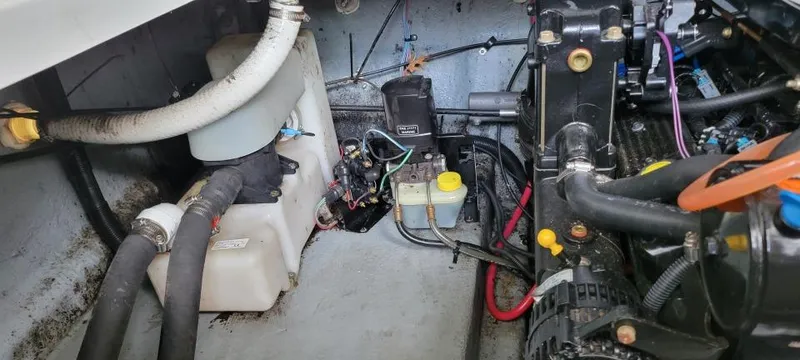 Slide: The Image of Engine compartment of a 2004 Sea Ray Sundancer 260 boat, showing various mechanical components. - 30