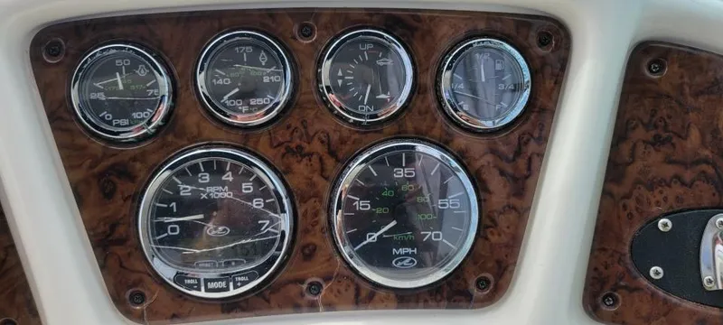 Slide: The Image of Dashboard of a 2004 Sea Ray Sundancer 260 boat with gauges and wood paneling. - 33