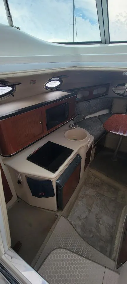 Slide: The Image of 2004 Sea Ray Sundancer 260 cabin interior with kitchenette and seating area. - 45