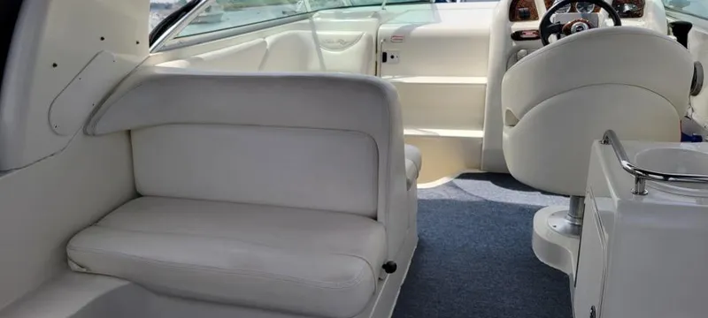 Slide: The Image of 2004 Sea Ray Sundancer 260 interior with white seating and helm. - 46