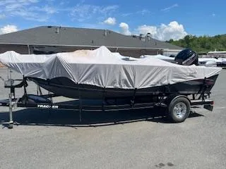 Slide: The Image of 2015 Tracker Pro Guide V-175 SC boat covered on trailer, parked outdoors. - 6