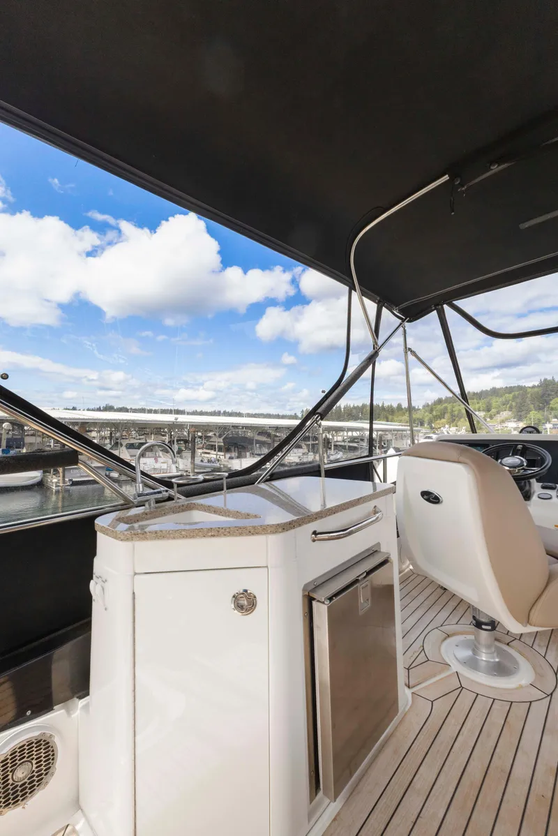 Slide: The Image of 2017 Sea Ray Fly 400 yacht interior with sleek design and marina view. - 13