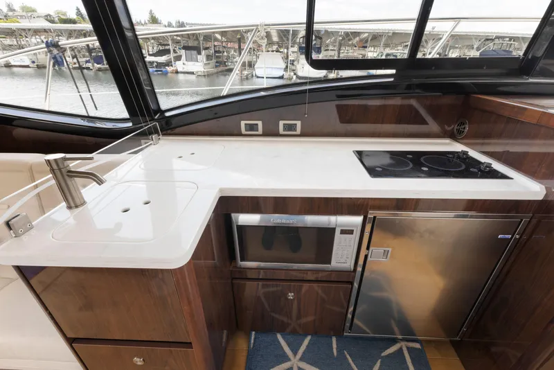Slide: The Image of Modern kitchen area in 2017 Sea Ray Fly 400 yacht with sink, stove, and microwave. - 15