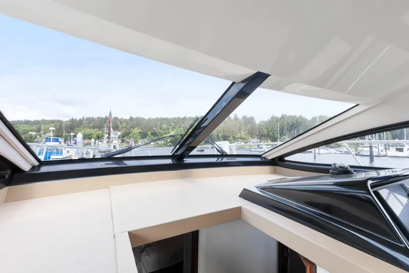 Slide: The Image of Interior view from 2017 Sea Ray Fly 400 yacht, showcasing marina and forested shoreline. - 18