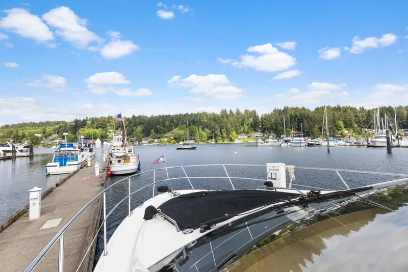 Slide: The Image of 2017 Sea Ray Fly 400 yacht docked at scenic marina with blue sky and lush greenery. - 32