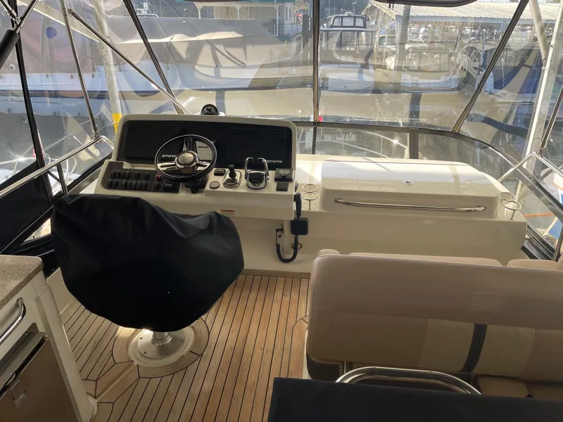 Slide: The Image of 2017 Sea Ray Fly 400 yacht helm with covered captain's chair and navigation controls. - 49