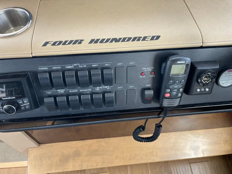 Slide: The Image of Control panel of a 2017 Sea Ray Fly 400 boat with switches and communication devices. - 57