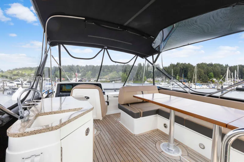 Slide: The Image of 2017 Sea Ray Fly 400 yacht interior with seating and table, overlooking marina. - 6