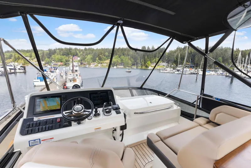 Slide: The Image of Flybridge view of 2017 Sea Ray Fly 400 yacht at marina, featuring helm and seating. - 68