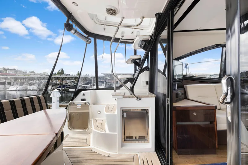 Slide: The Image of 2017 Sea Ray Fly 400 yacht interior with seating, stairs, and marina view. - 9