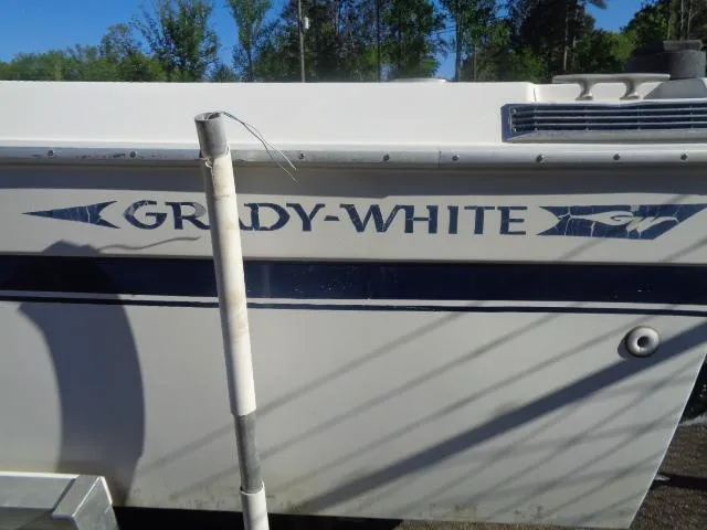 Slide: The Image of 1980 Grady-White 241 Weekender boat side view with logo and trees in background. - 15