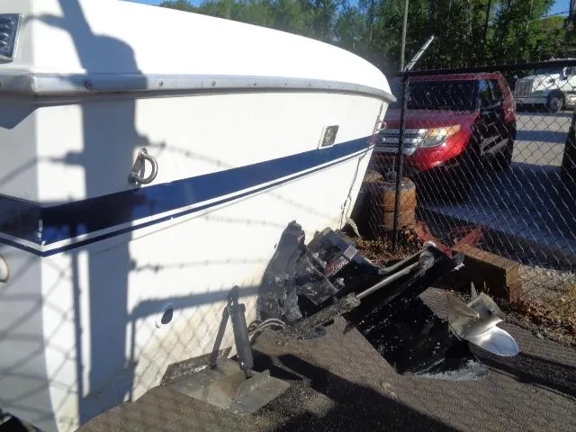 Slide: The Image of 1980 Grady-White 241 WEEKENDER boat with visible outboard motor, parked near a fence. - 4