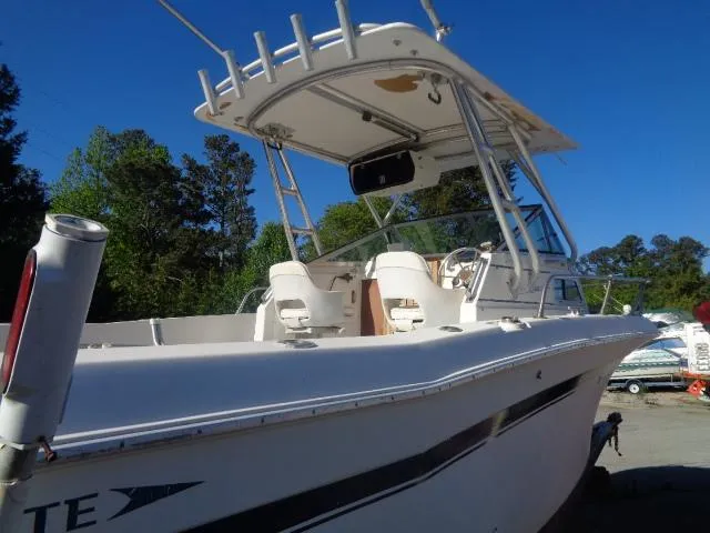Slide: The Image of 1980 Grady-White 241 WEEKENDER boat with canopy, docked outdoors under clear blue sky. - 5