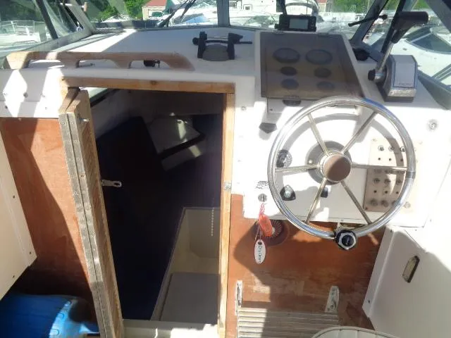 Slide: The Image of 1980 Grady-White 241 WEEKENDER boat interior with steering wheel and cabin entrance. - 8