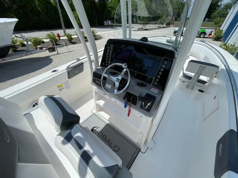 Slide: The Image of 2021 Robalo R242 Explorer boat cockpit with steering wheel and control panel. - 11