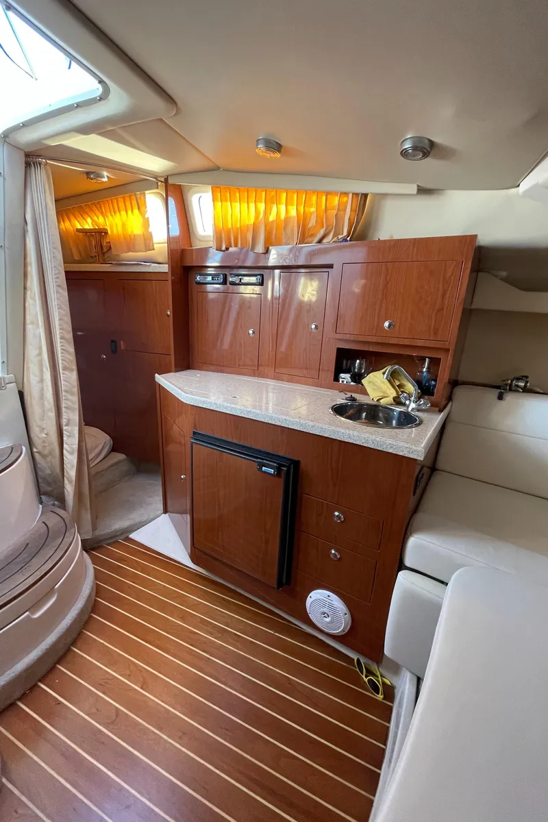 Slide: The Image of 2006 Regal 3060 Window Express cabin interior with wood finish and compact kitchenette. - 11