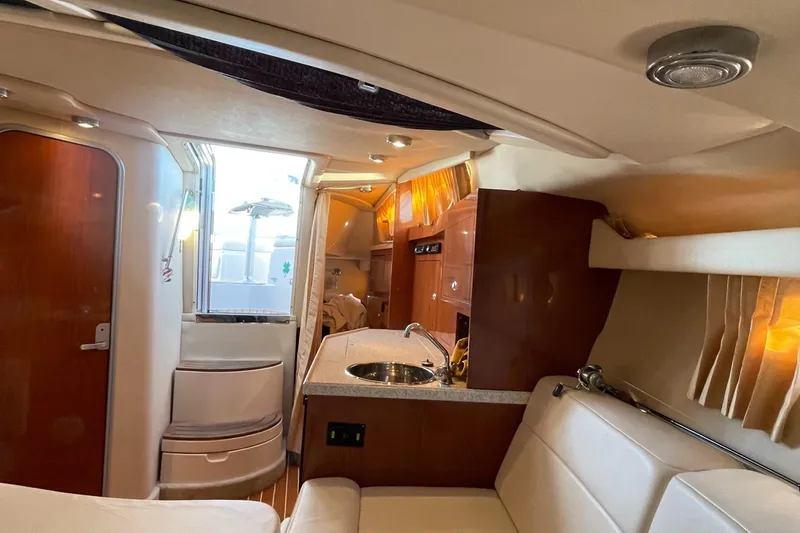 Slide: The Image of Interior of 2006 Regal 3060 Window Express yacht, featuring kitchenette and seating area. - 12