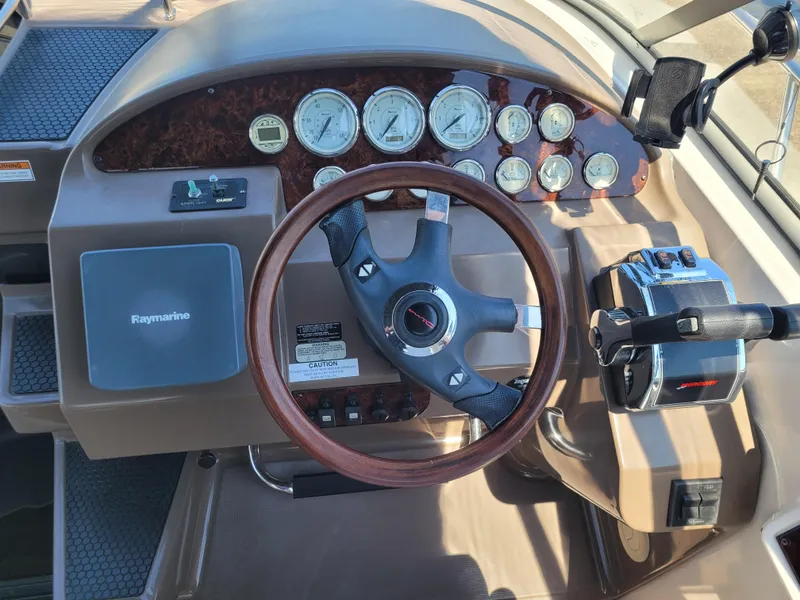 Slide: The Image of 2006 Regal 3060 Window Express boat dashboard with gauges, steering wheel, and controls. - 19
