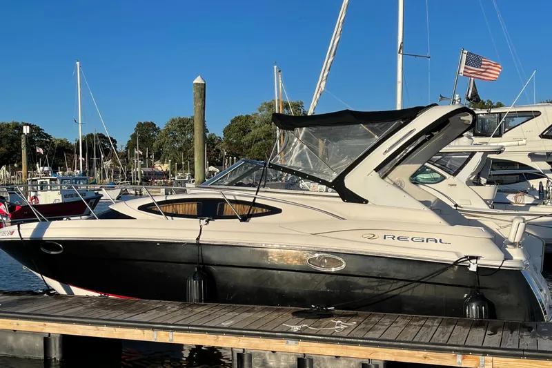 Slide: The Image of 2006 Regal 3060 Window Express boat docked at marina under clear blue sky. - 2