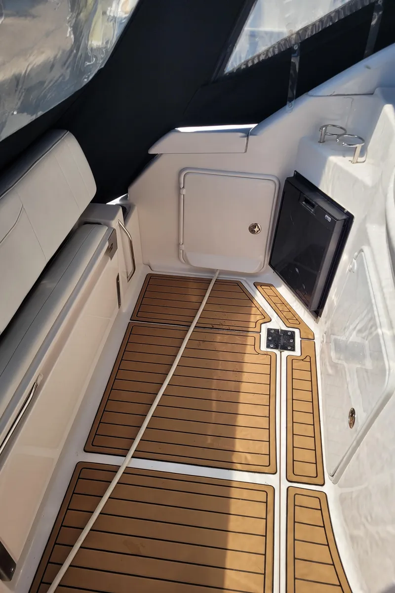 Slide: The Image of 2006 Regal 3060 Window Express boat interior with teak flooring and storage compartments. - 24