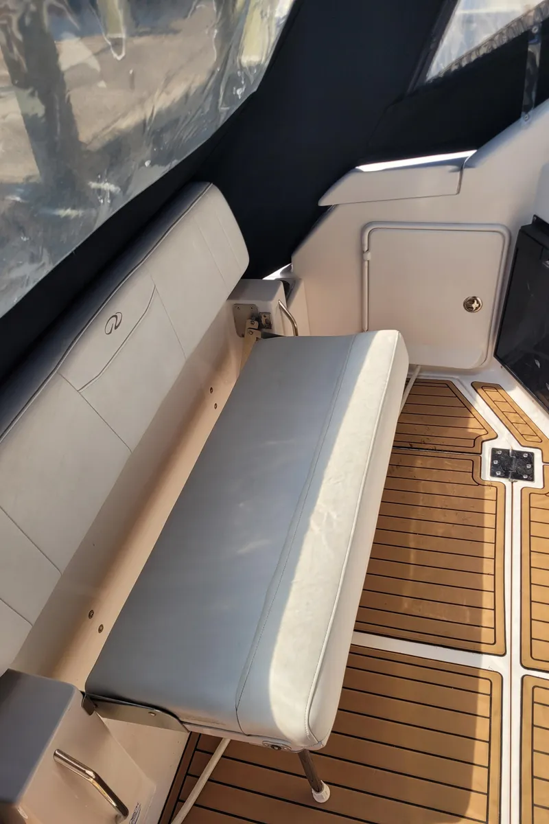 Slide: The Image of 2006 Regal 3060 Window Express boat interior with cushioned seating and wood-patterned flooring. - 25