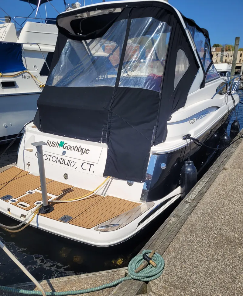 Slide: The Image of 2006 Regal 3060 Window Express boat docked, featuring a covered cabin and wooden deck. - 27