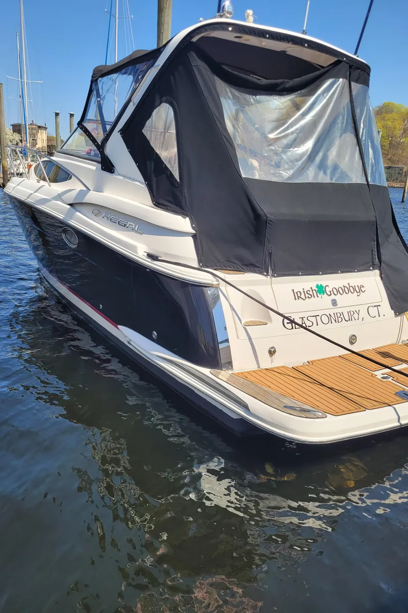 Slide: The Image of 2006 Regal 3060 Window Express boat docked, featuring black canopy and wooden deck. - 29