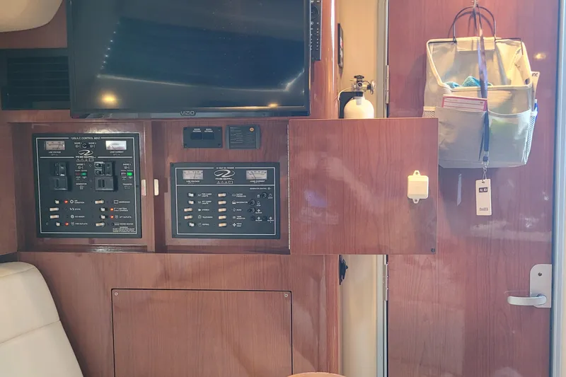Slide: The Image of Interior of a 2006 Regal 3060 Window Express boat with control panels and a mounted TV. - 30