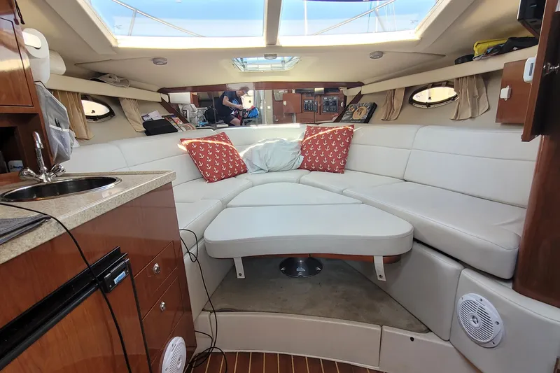 Slide: The Image of Interior of a 2006 Regal 3060 Window Express boat with white seating and red cushions. - 32