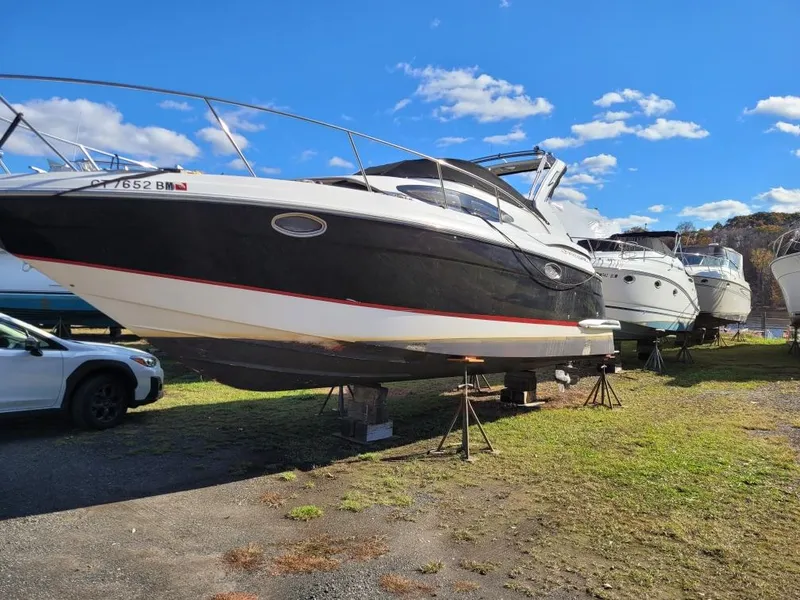 Slide: The Image of 2006 Regal 3060 Window Express boat on land, sunny day, blue sky, parked cars nearby. - 38