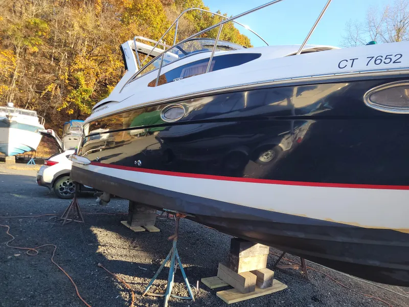 Slide: The Image of 2006 Regal 3060 Window Express boat on stands, outdoors, with autumn foliage background. - 39