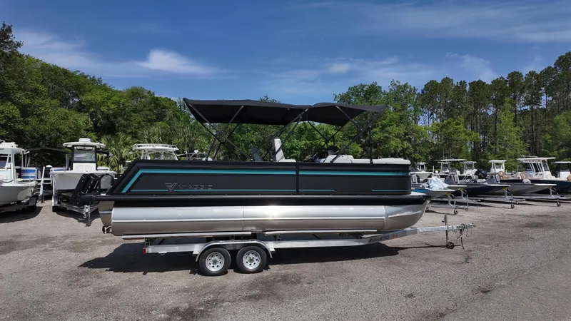 Slide: The Image of 2025 Viaggio Z22S pontoon boat on trailer, parked outdoors with trees in background. - 17