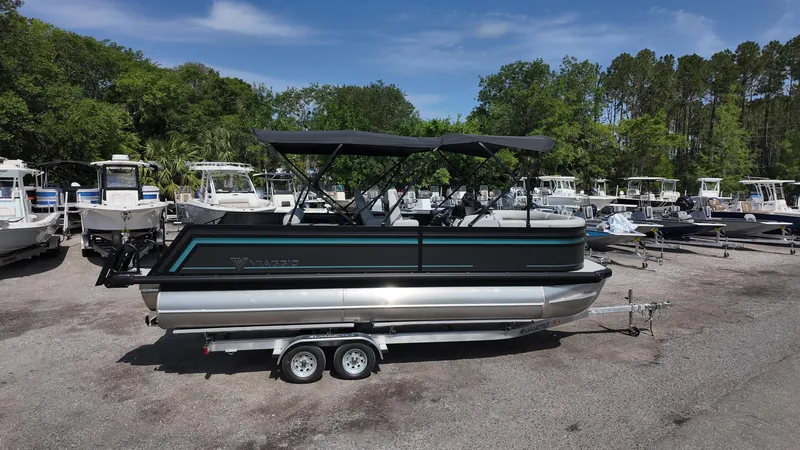 Slide: The Image of 2025 Viaggio Z22S pontoon boat on trailer, surrounded by other boats, under clear blue sky. - 18