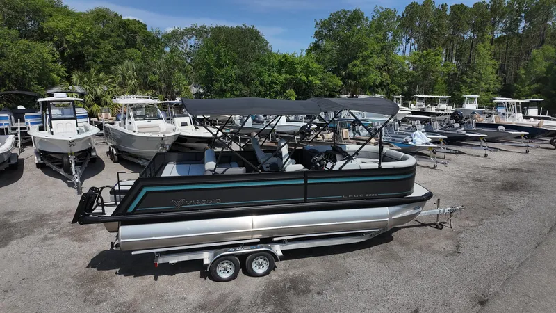 Slide: The Image of 2025 Viaggio Z22S pontoon boat on trailer, surrounded by other boats, in a marina setting. - 19