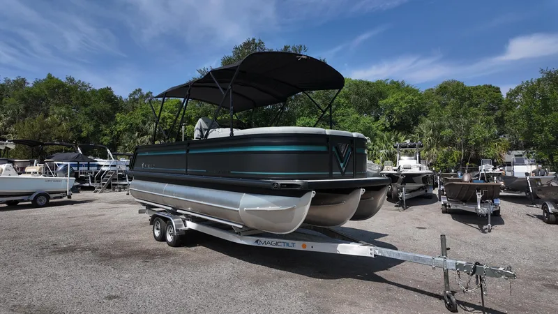 Slide: The Image of 2025 Viaggio Z22S pontoon boat on trailer, parked outdoors under clear sky. - 2