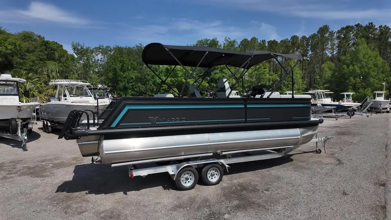 Slide: The Image of 2025 Viaggio Z22S pontoon boat on trailer, parked outdoors with trees in background. - 21