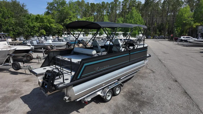 Slide: The Image of 2025 Viaggio Z22S pontoon boat on trailer, parked in marina lot with other boats. - 24
