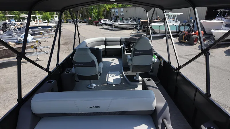 Slide: The Image of 2025 Viaggio Z22S pontoon boat interior with seating and helm, docked at marina. - 31