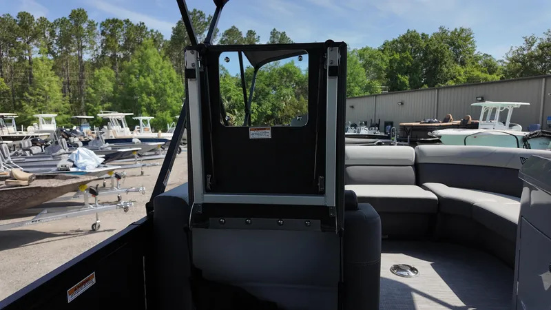 Slide: The Image of 2025 Viaggio Z22S pontoon boat interior with seating and storage, surrounded by trees and other boats. - 44