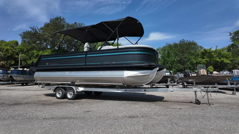 Slide: The Image of 2025 Viaggio Z22S pontoon boat on trailer, parked outdoors under clear sky. - 7