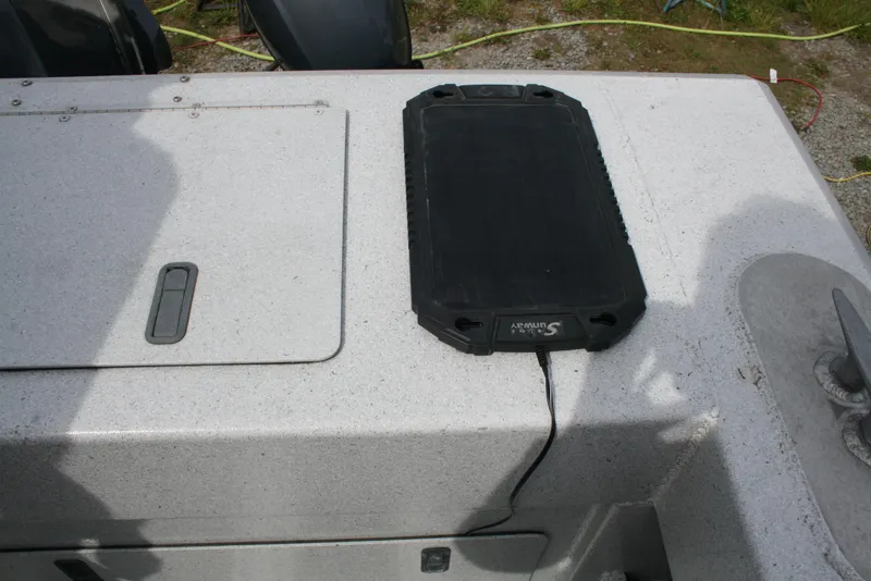 Slide: The Image of 2017 North River 2500 S Sew Hawk OS boat deck with a black device charging. - 12