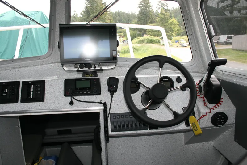 Slide: The Image of 2017 North River 2500 S Sew Hawk OS boat cockpit with steering wheel and navigation equipment. - 2