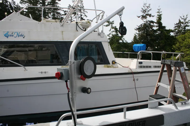 Slide: The Image of 2017 North River 2500 S Sew Hawk OS boat docked with equipment and trees in background. - 35