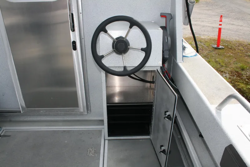 Slide: The Image of Steering wheel and storage compartment in 2017 North River 2500 S Sew Hawk OS boat. - 7