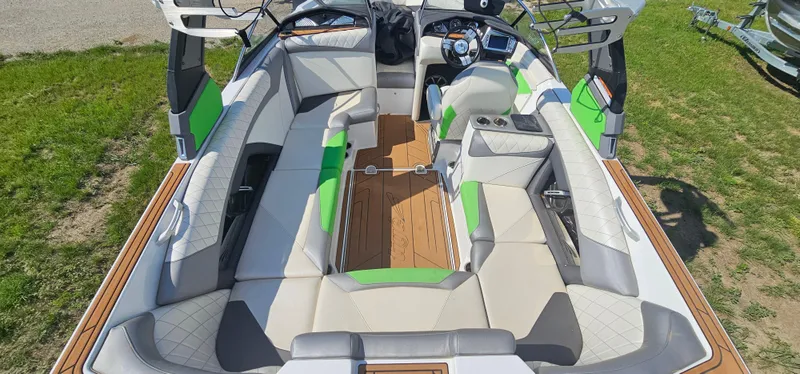 Slide: The Image of 2017 Tigé Z3 boat interior with green accents and spacious seating on grass. - 11